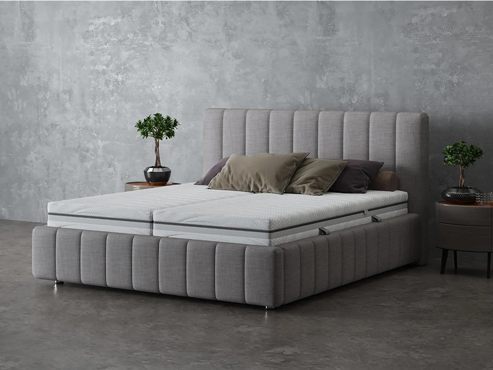 Elastica Boxspringbett mit grauem Stoffbezug und getrennten Matratzen im Schlafzimmer
