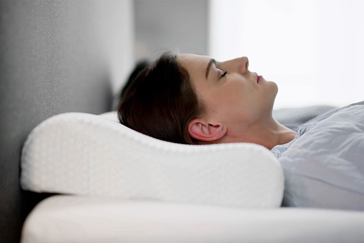 Frau mit orthopaedischem Nackenkissen