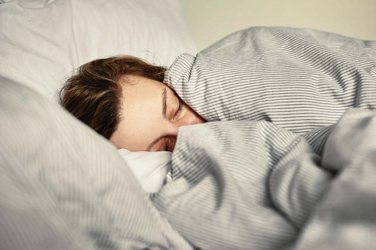 Frau im Bett mit Schwangerschaftskissen