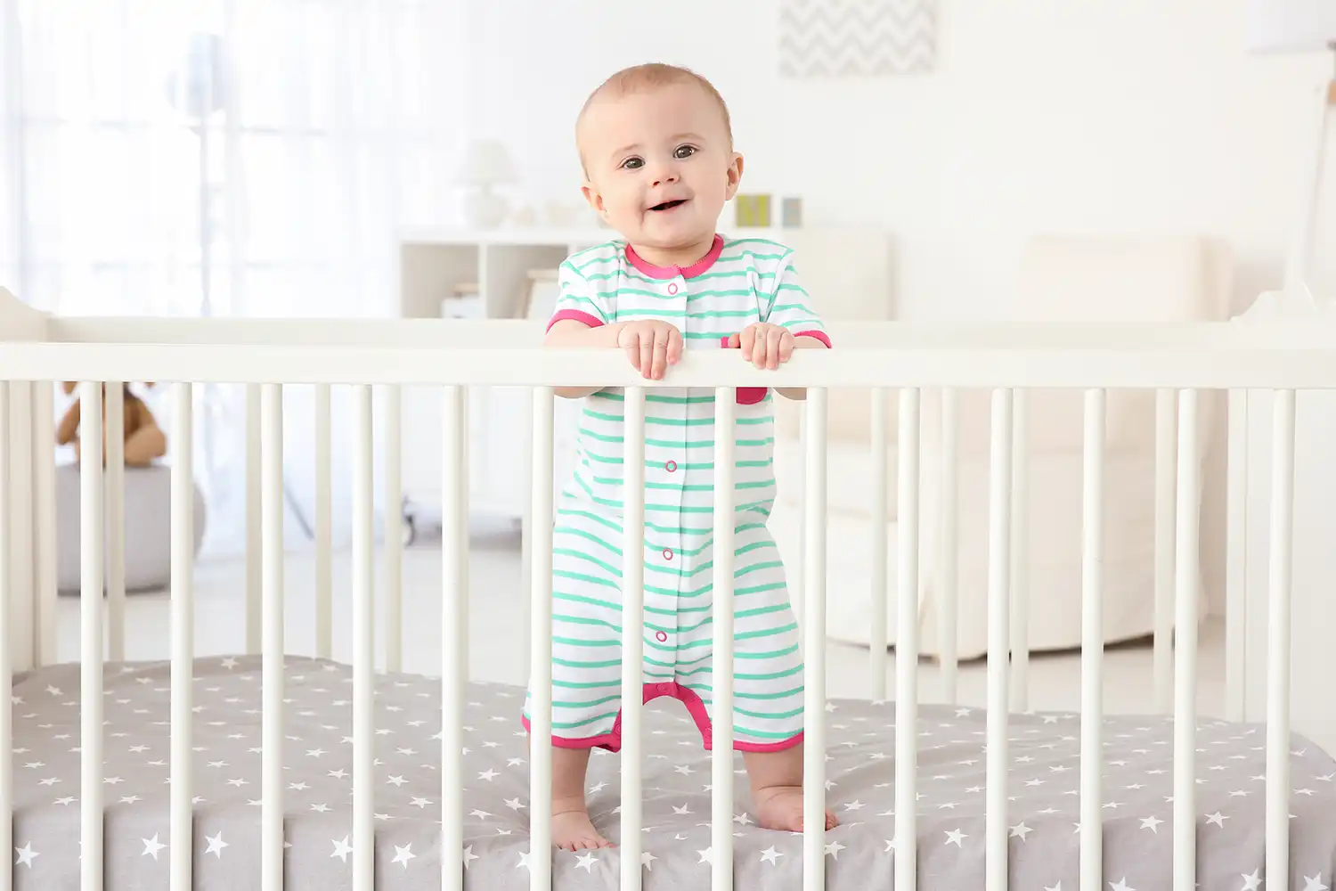 Baby steht auf Kinderbett Matratze